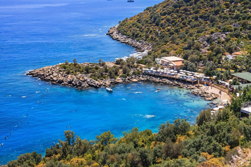 Tuffatore a mezz'aria durante le avventure acquatiche di yachting in Turchia nella baia di Hidayet, con attrezzatura da kitesurf sul ponte dello yacht.